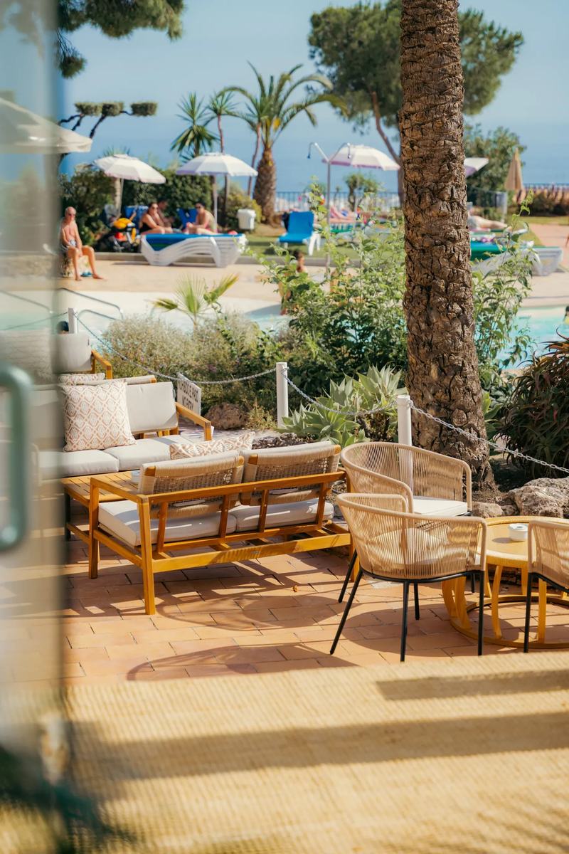 La terrasse de Tardeo, avec ses canapés et ses palmiers, et la piscine au fond