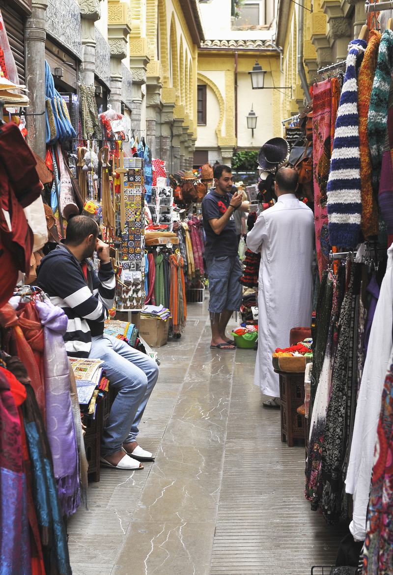 Une ruelle étroite de l’Alcaicería de Grenade, bordée de boutiques de tissus, de lampes et de souvenirs