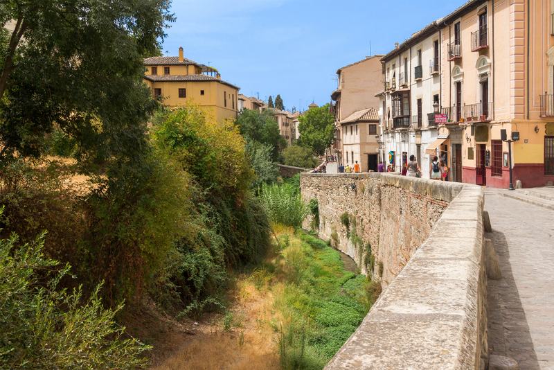 La Carrera del Darro, avec le Darro à gauche entre les arbres et les maisons colorées de l’Albaicín à droite