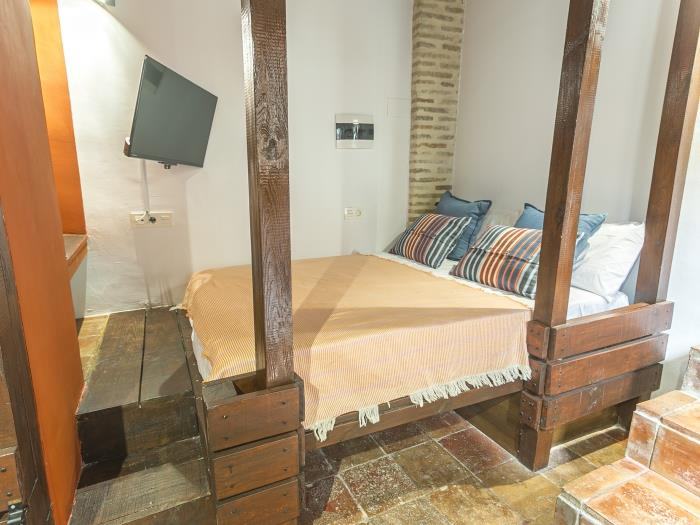 La Chili Red Room, une petite chambre avec lit double, poutres en bois et coussins rayés