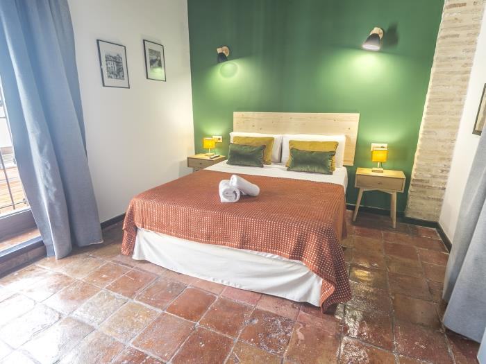 La Green Room, avec son mur vert derrière le lit double et son sol en terre cuite