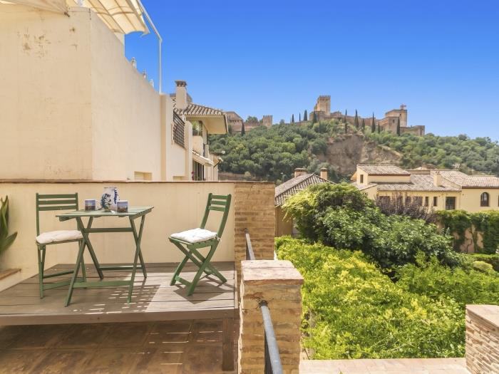 La terrasse privée de la Yellow Room, avec table et chaises, face à l’Alhambra